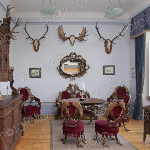 Traditional furniture and hunting trophies, carved chest of drawers, wall plaques and… Traditional furniture and hunting trophies, carved chest of drawers, wall plaques and…
