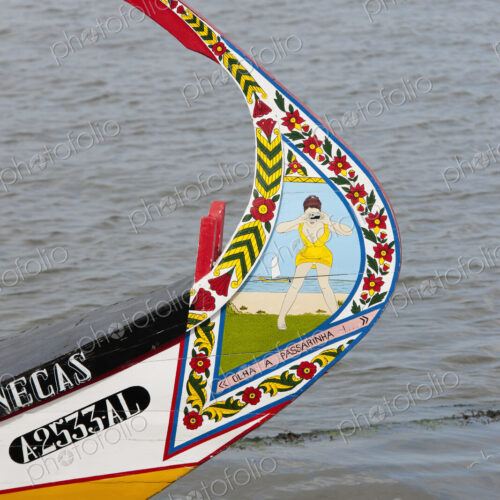 Traditional moliceiro fishing boat with a high prow, painted in vivid colours and with… Traditional moliceiro fishing boat with a high prow, painted in vivid colours and with…