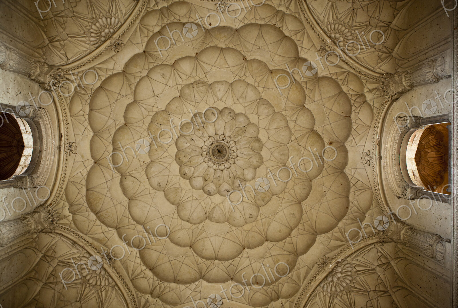 Traditional scalloped shaped patterns on a ceiling in concentric circles seen from…
