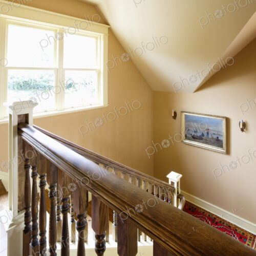 Traditional staircase of house with window and portrait.