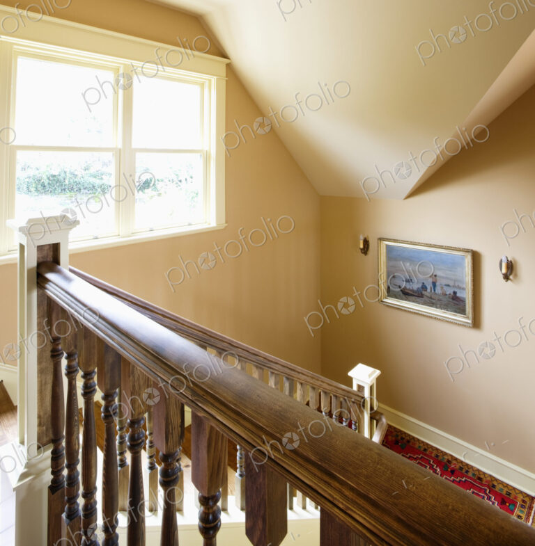 Traditional staircase of house with window and portrait.