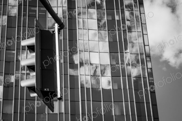Traffic light and clouds reflected in glass facade in Berlin, Germany.