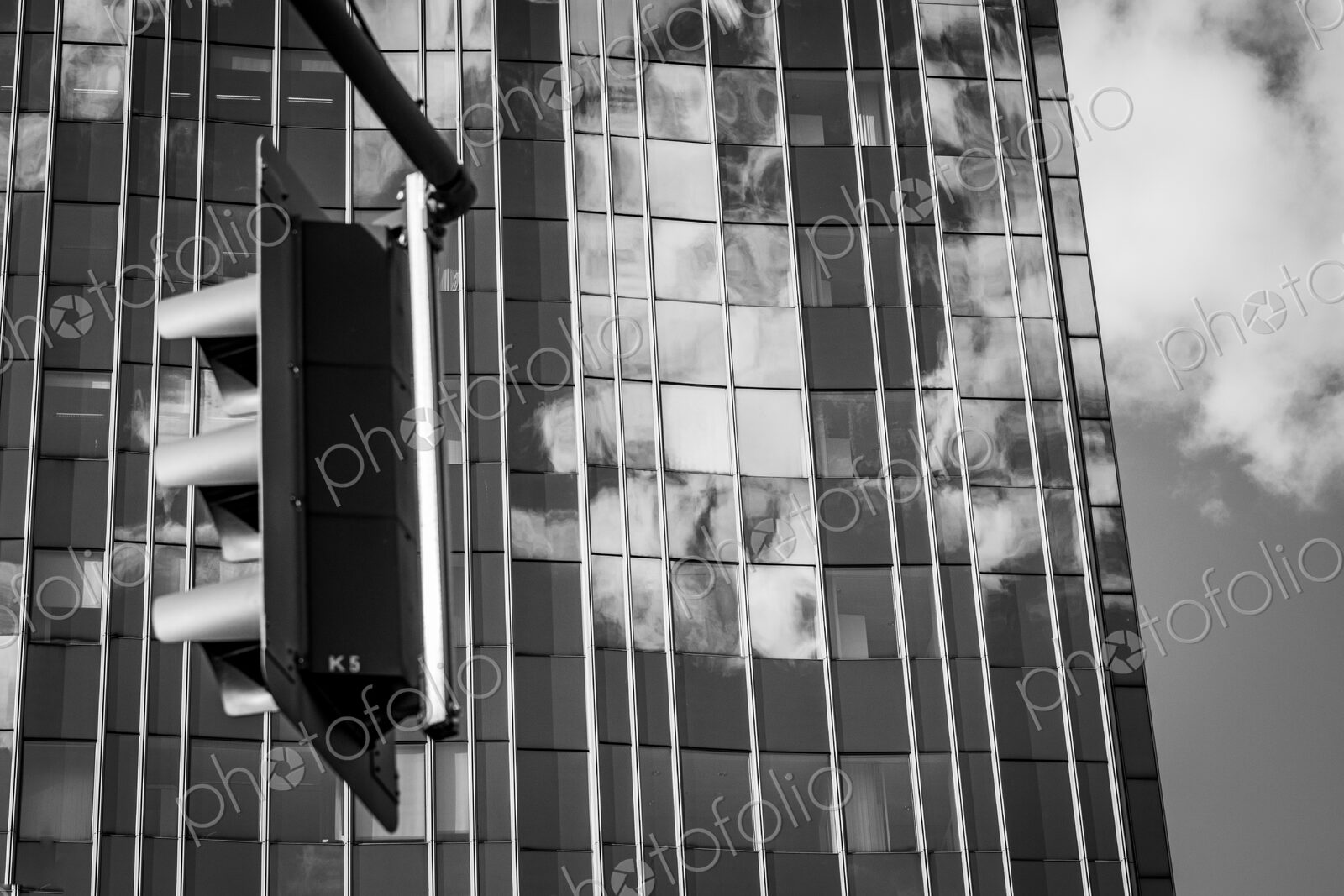 Traffic light and clouds reflected in glass facade in Berlin, Germany.