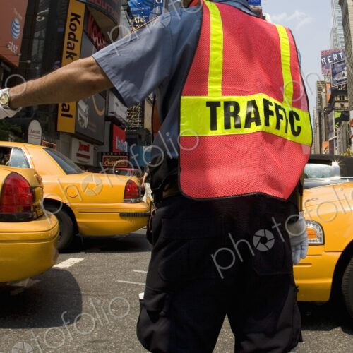 Traffic officer directing rush hour traffic on urban street, yellow cabs passing. Traffic officer directing rush hour traffic on urban street, yellow cabs passing.