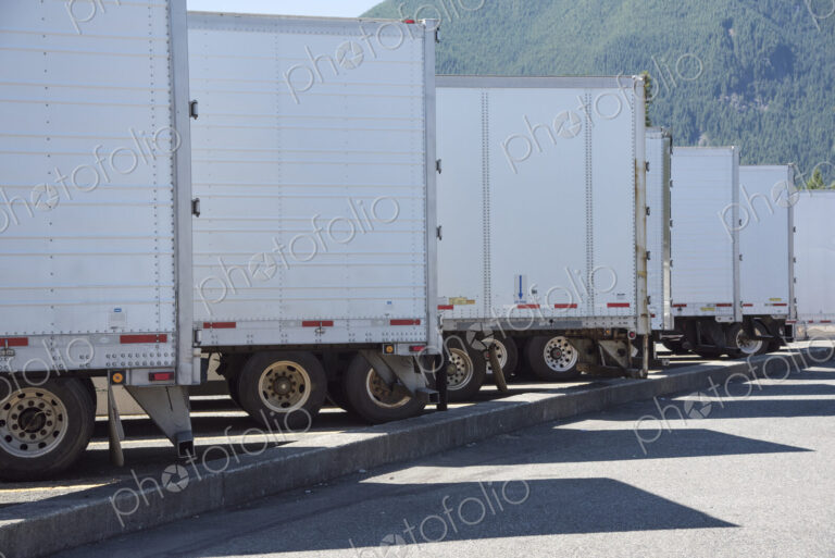 Trailers lined up in a truck stop parking lot.