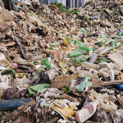 Trash Mound with Modern Office Buildings Behind