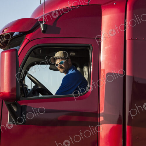 Truck driver, man in a red lorry cab. Truck driver, man in a red lorry cab.
