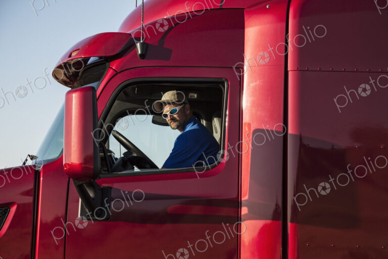 Truck driver, man in a red lorry cab.