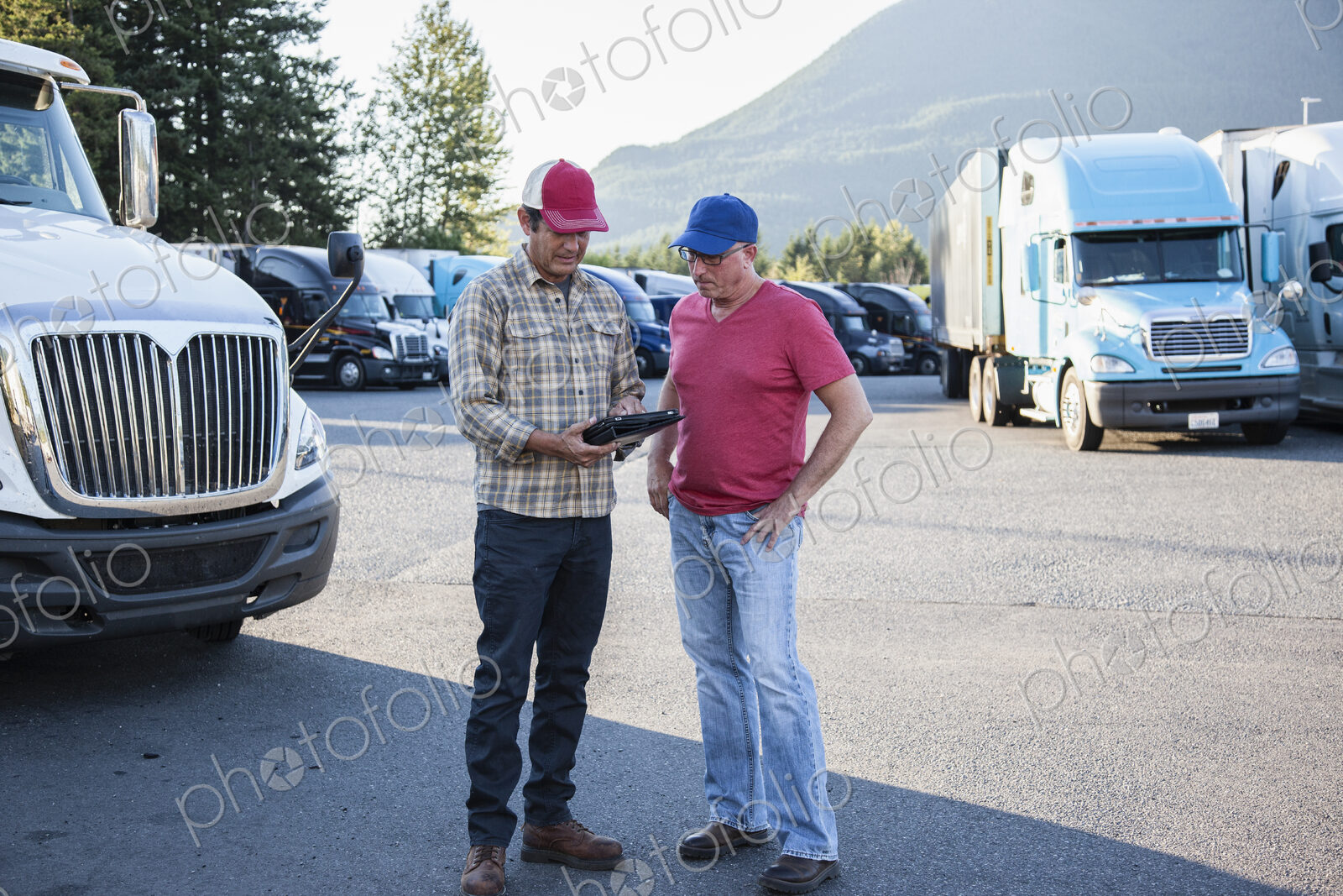 Truck driver team of caucasian drivers going over dispatch information in the parking…