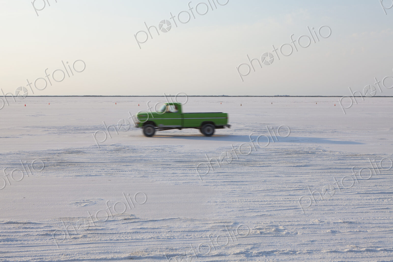 Truck driving on Bonneville Salt Flats, during Speed Week, dusk