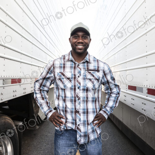 Trucker standing by his large truck Trucker standing by his large truck