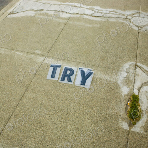 'Try' Sign in blue letters on a sidewalk, encouragement and motivation. 'Try' Sign in blue letters on a sidewalk, encouragement and motivation.