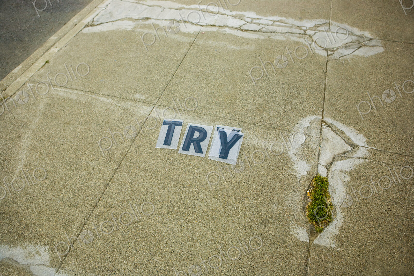 ‘Try’ Sign in blue letters on a sidewalk, encouragement and motivation.