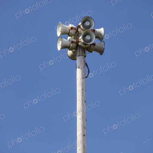 Tsunami warning system with multiple loudspeakers mounted on a tall wooden pole…