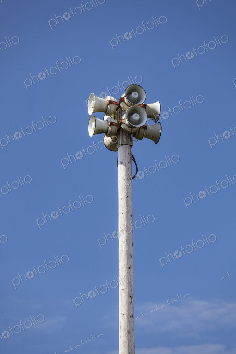 Tsunami warning system with multiple loudspeakers mounted on a tall wooden pole…