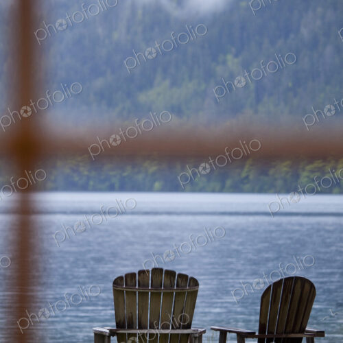 Two Adirondack style wooden lounge chairs at Crescent Lake Lodge at Olympic National Park.