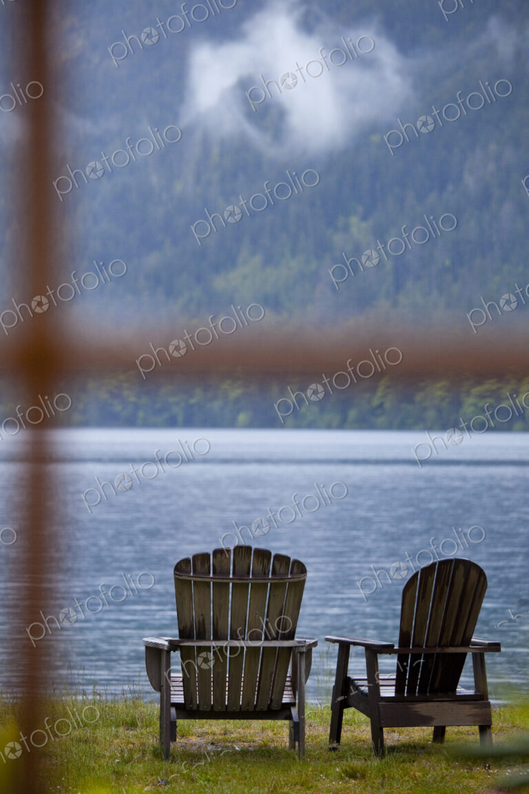 Two Adirondack style wooden lounge chairs at Crescent Lake Lodge at Olympic National Park.