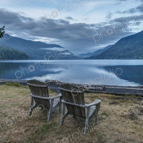 Two Adirondack style wooden lounge chairs at Crescent Lake Lodge at Olympic National Park.