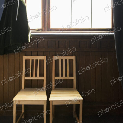 Two Empty Chairs Beneath a Window