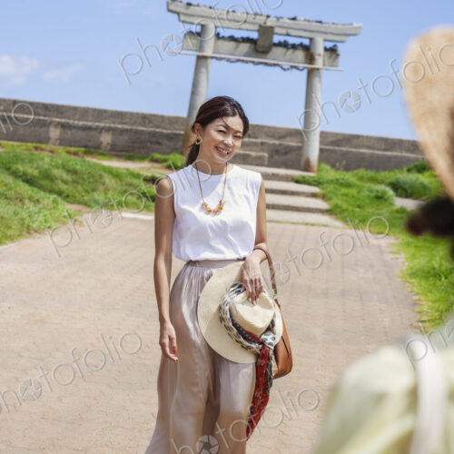 Two Japanese woman wearing hats standing on a path, taking picture. Two Japanese woman wearing hats standing on a path, taking picture.