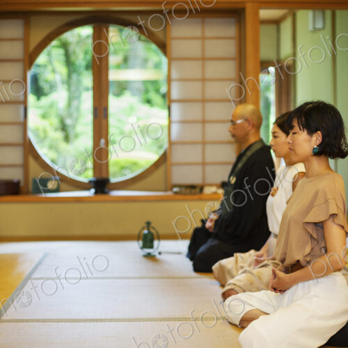 Two Japanese women and Buddhist priest kneeling in Buddhist temple, praying. Two Japanese women and Buddhist priest kneeling in Buddhist temple, praying.