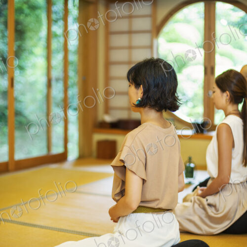 Two Japanese women and Buddhist priest kneeling in Buddhist temple, praying. Two Japanese women and Buddhist priest kneeling in Buddhist temple, praying.