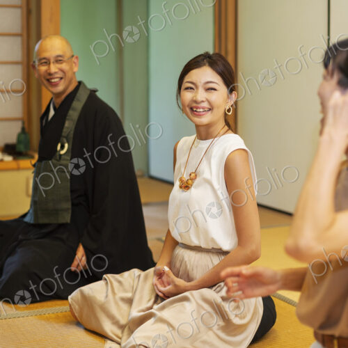 Two Japanese women and Buddhist priest kneeling in Buddhist temple, talking. Two Japanese women and Buddhist priest kneeling in Buddhist temple, talking.