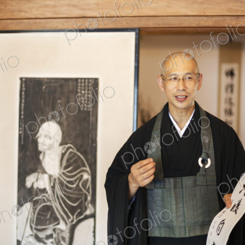 Two Japanese women and Buddhist priest standing in Buddhist temple, talking. Two Japanese women and Buddhist priest standing in Buddhist temple, talking.