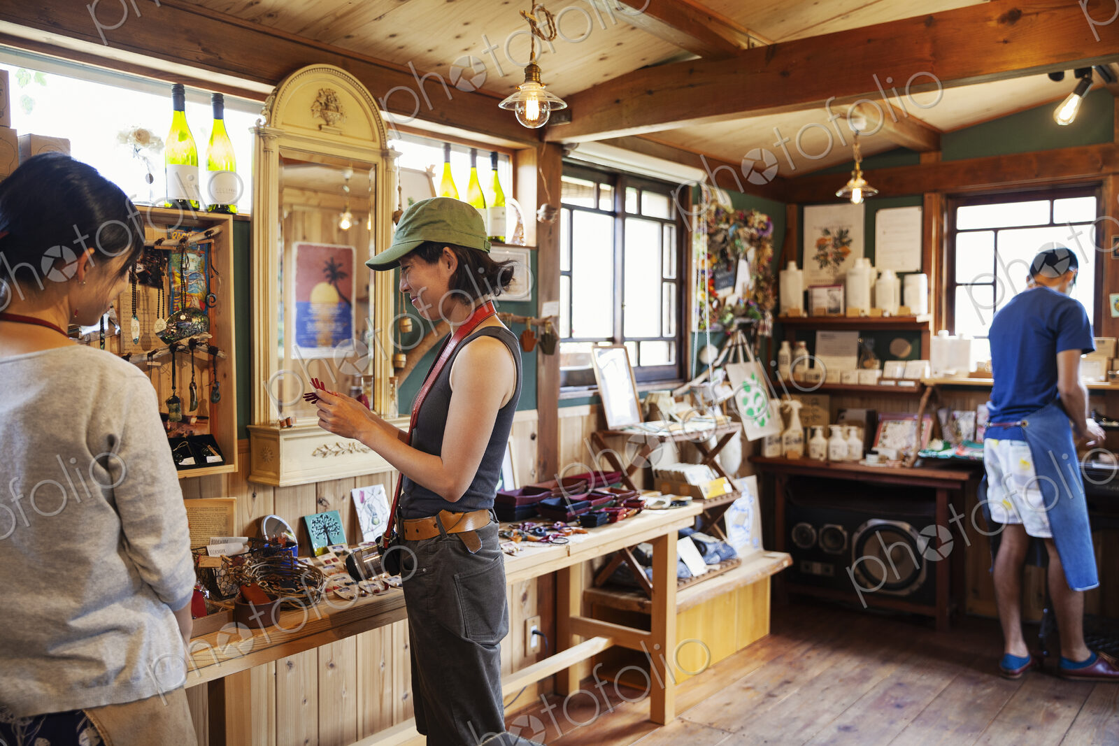Two Japanese women and man standing in a leather shop.