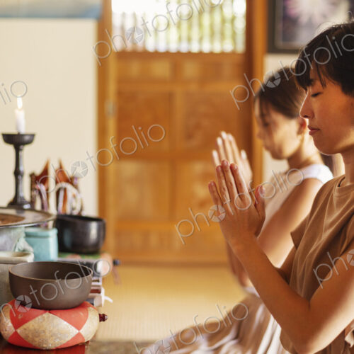 Two Japanese women kneeling in Buddhist temple, praying. Two Japanese women kneeling in Buddhist temple, praying.