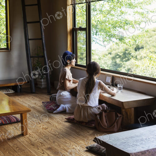 Two Japanese women sitting at a table in a Japanese restaurant, eating. Two Japanese women sitting at a table in a Japanese restaurant, eating.