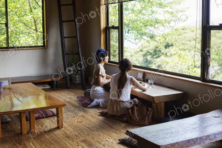 Two Japanese women sitting at a table in a Japanese restaurant, eating.
