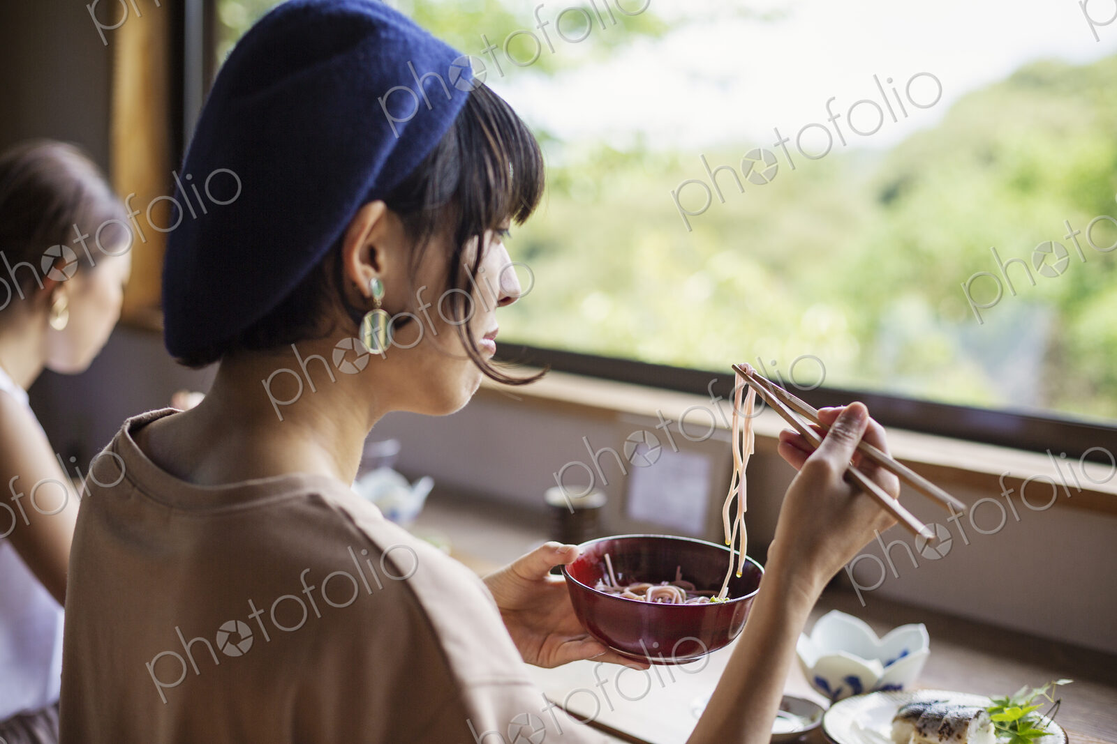 Two Japanese women sitting at a table in a Japanese restaurant, eating.