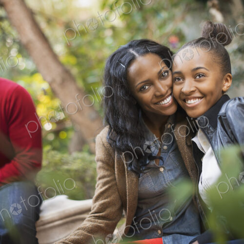 Two adults and a teenage girl, mother and daughter hugging. Two adults and a teenage girl, mother and daughter hugging.