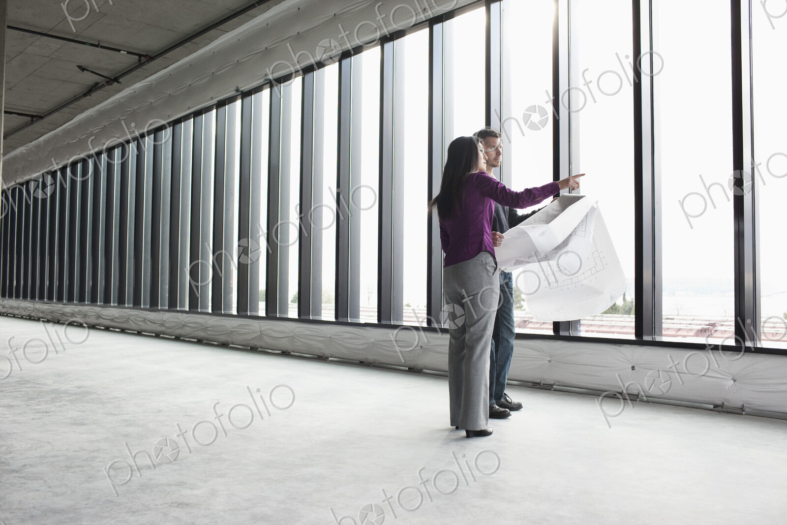 Two architects working on business plans in a new raw business space.