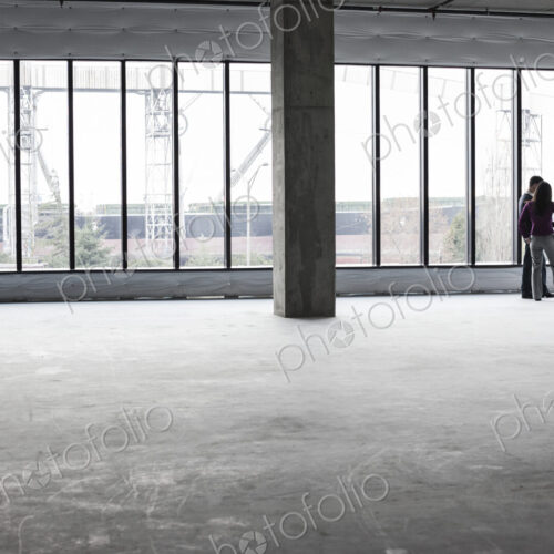 Two architects working on business plans in a new raw business space.