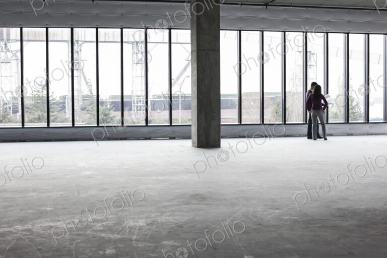 Two architects working on business plans in a new raw business space.