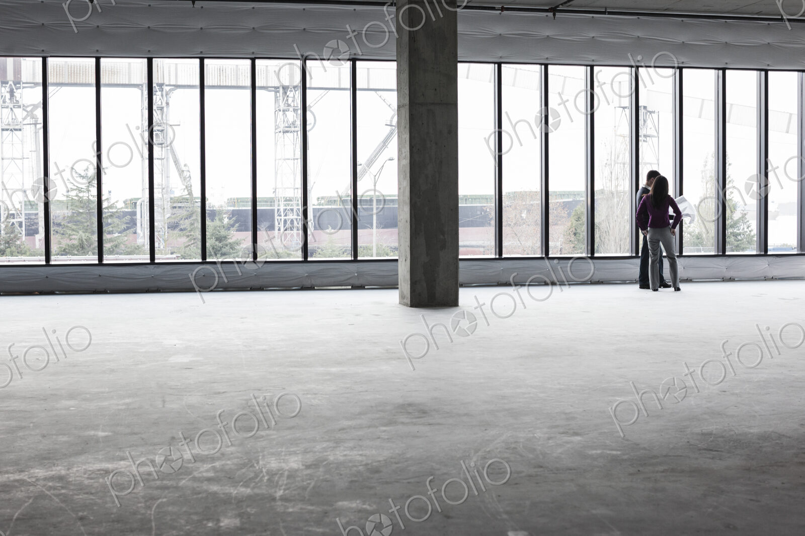 Two architects working on business plans in a new raw business space.