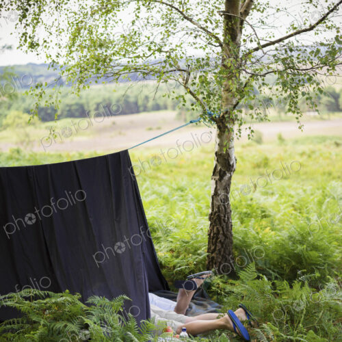 Two boys camping in the New Forest lying under a canvas shelter. Two boys camping in the New Forest lying under a canvas shelter.