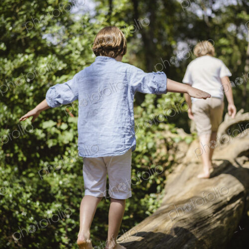 Two boys camping in the New Forest. Walking along a log above the water, balancing… Two boys camping in the New Forest. Walking along a log above the water, balancing…
