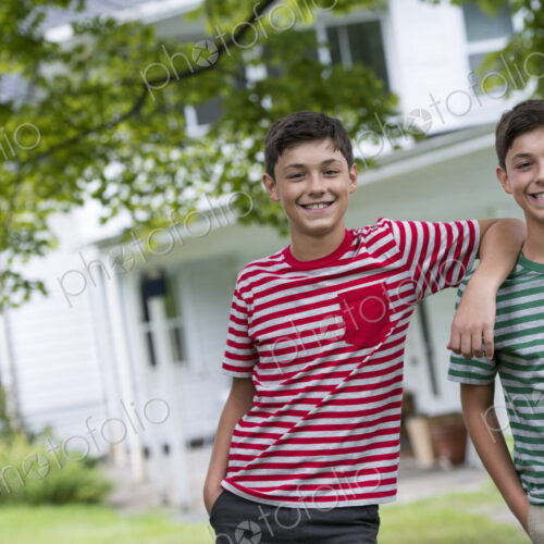 Two boys in a farmhouse garden in summer.