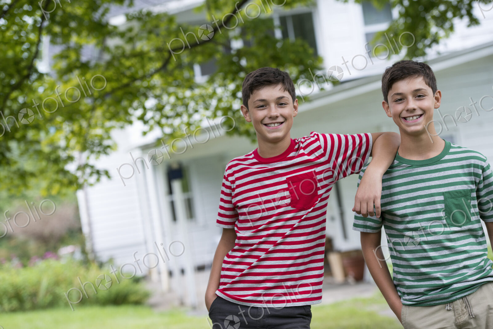 Two boys in a farmhouse garden in summer.