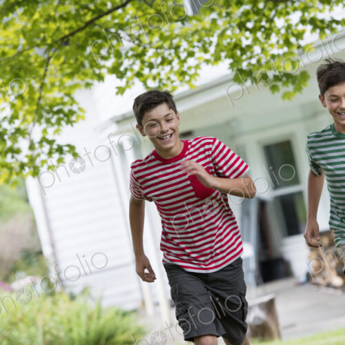 Two boys in a farmhouse garden in summer.