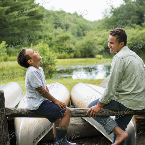 Two brothers playing by a lake.
