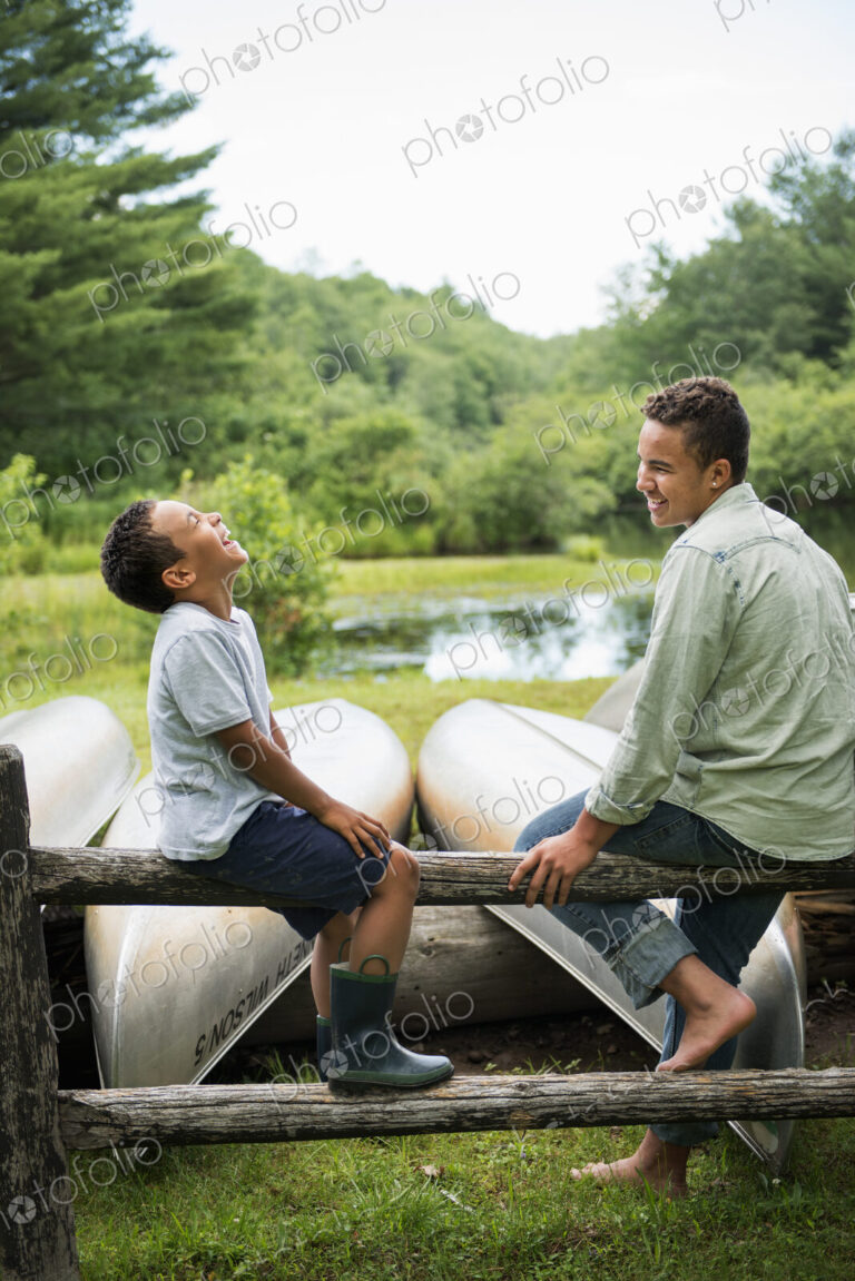 Two brothers playing by a lake.