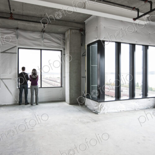 Two business owners standing in their new empty raw business space. Two business owners standing in their new empty raw business space.