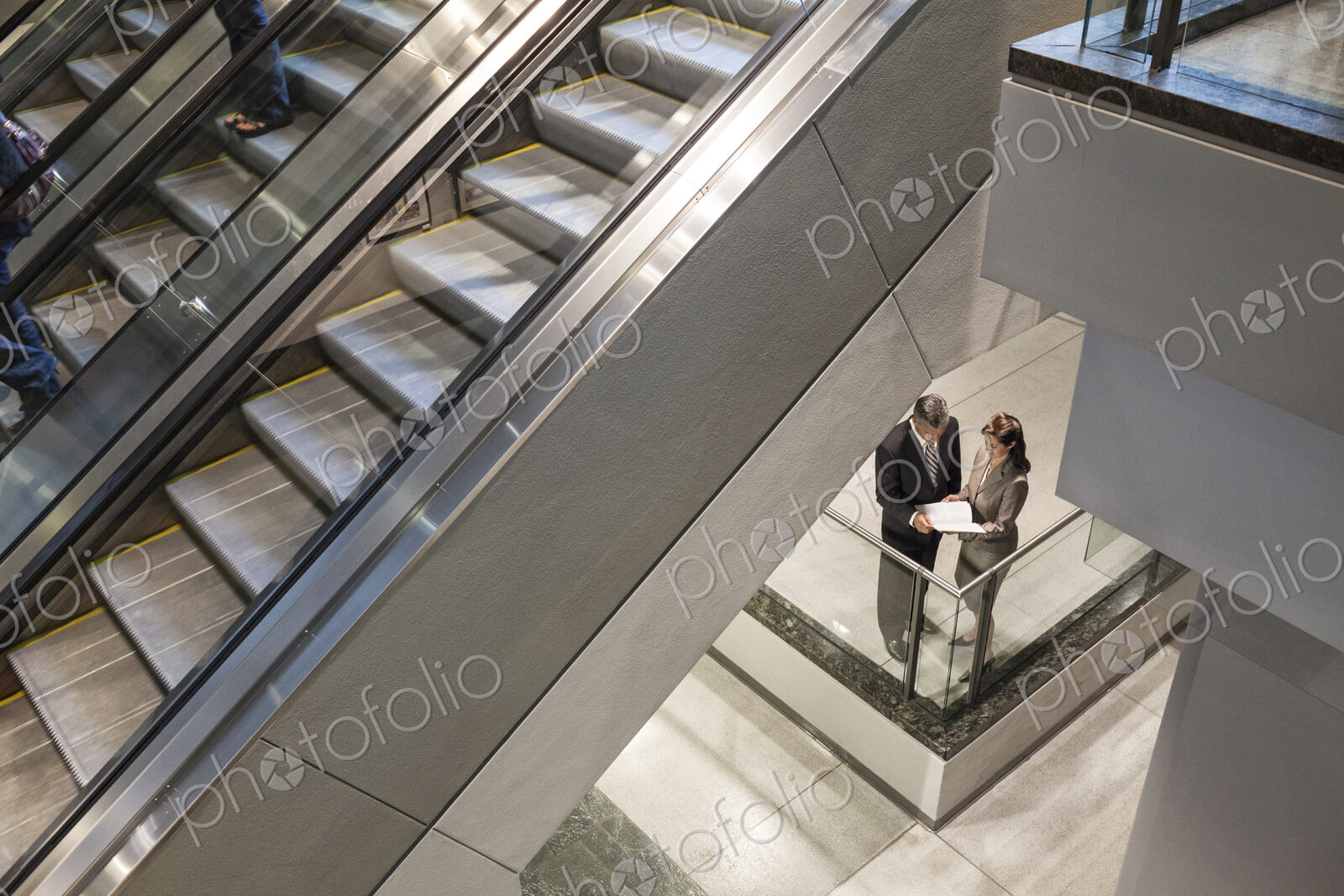 Two business people going over a report while standing next to a convention center…