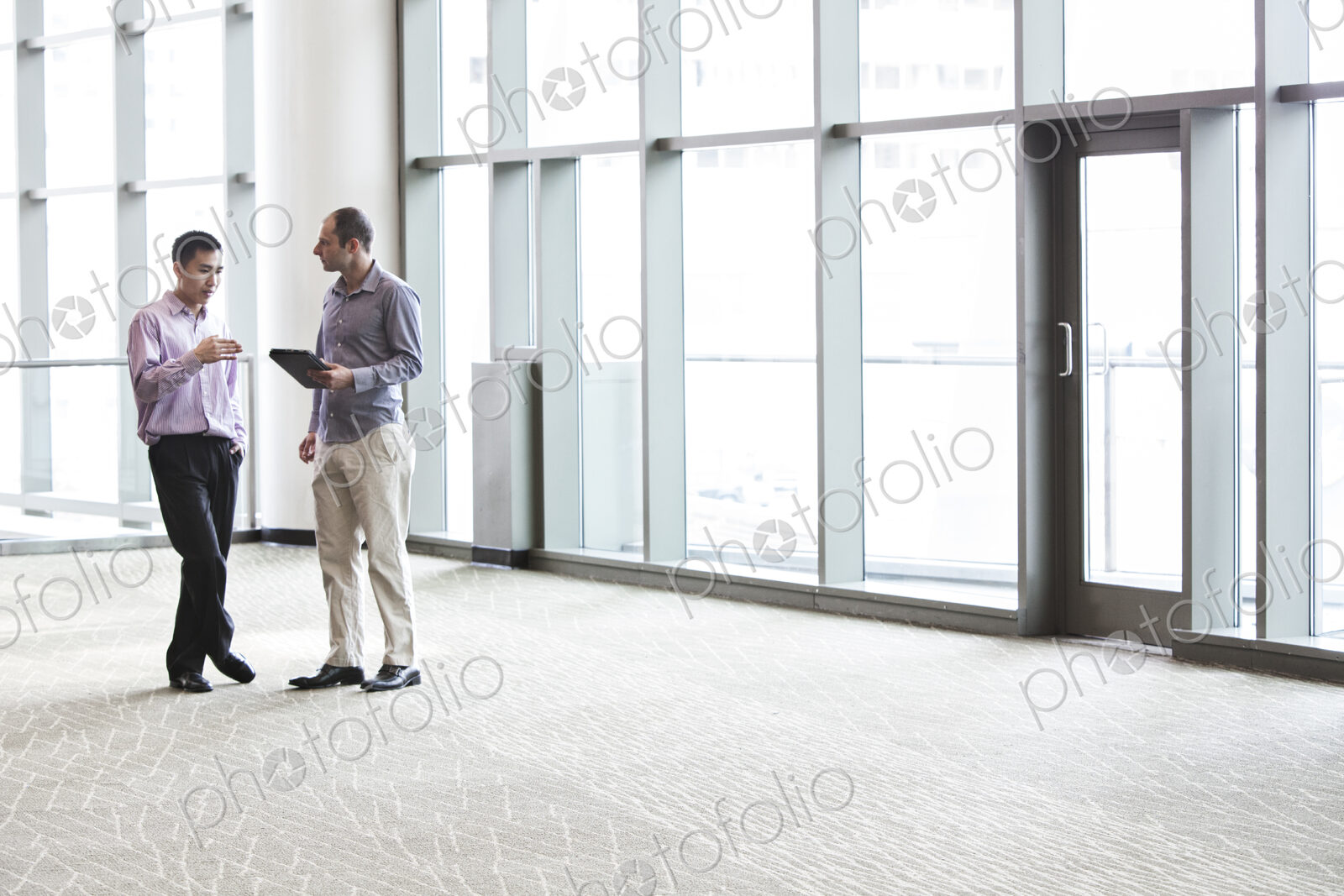 Two businessmen discussing an issue in the lobby of a business center.