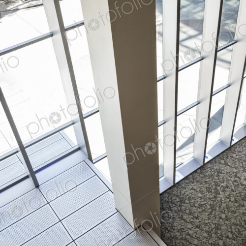 Two businessmen meeting next to a large bank of windows in a business center. Two businessmen meeting next to a large bank of windows in a business center.