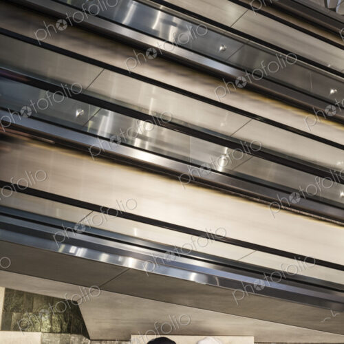 Two businessmen on a notebook computer near an escalator. Two businessmen on a notebook computer near an escalator.